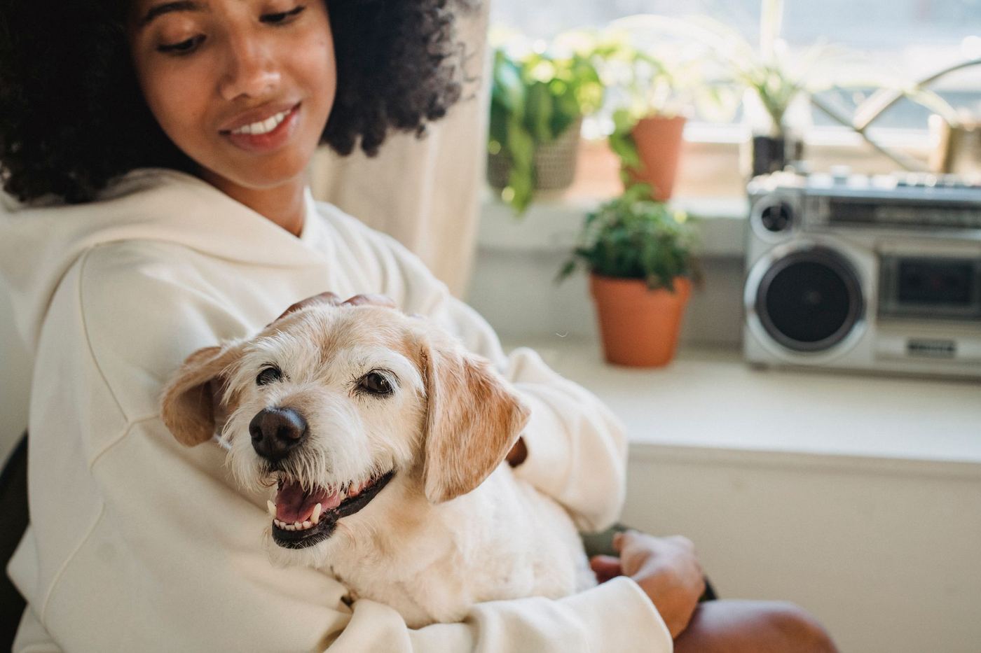 Tutora abrazando a su perro en casa